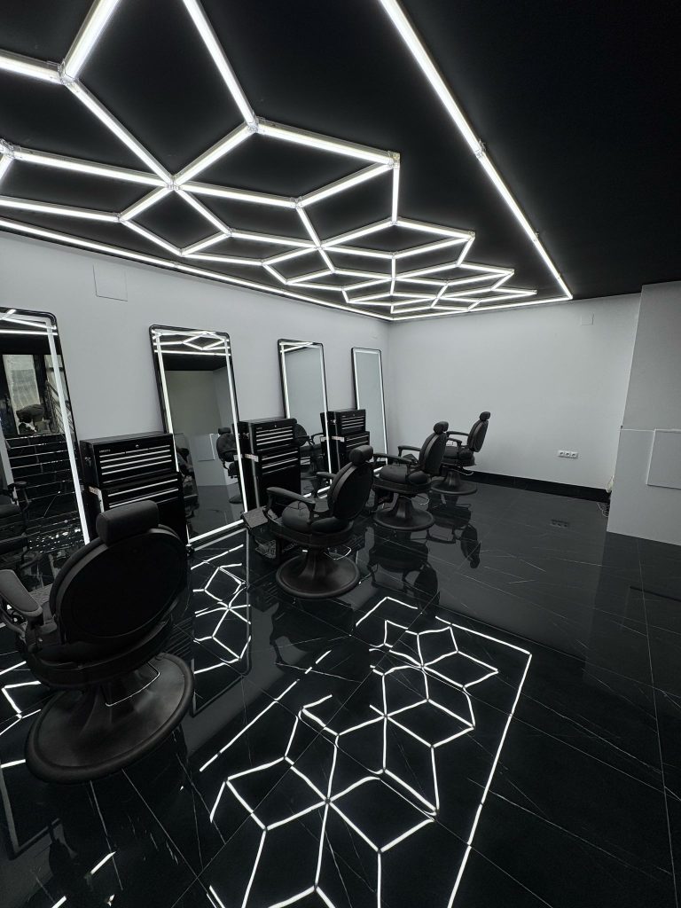 A barber shop interior featuring striking black and white lighting, creating a classic and stylish atmosphere.